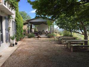 a group of picnic tables and benches next to a building at B&B Il Grotto in Bevagna