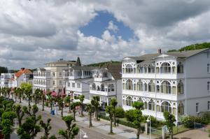 a row of white buildings with trees in front of them at Villa Meeresgruss in Ostseebad Sellin