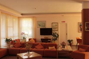 a living room with orange couches and a television at Hotel Fabiola in Giulianova