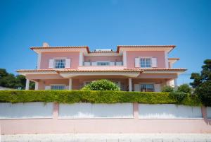 a pink house on a wall with ivy at Grace Villa in Aldeia de Juso