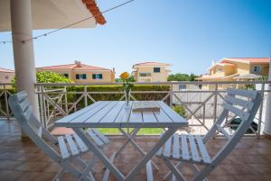 a blue table and two chairs on a balcony at Grace Villa in Aldeia de Juso