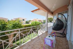 a balcony with a hammock on a house at Grace Villa in Aldeia de Juso