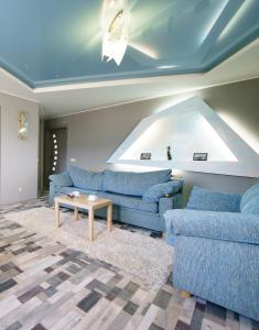 una sala de estar con 2 sofás azules y una mesa. en PaulMarie Apartments on Voinov Internatsionalistov, en Vitebsk
