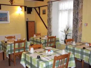 een eetkamer met twee tafels met groene en witte tafelkleden bij Ashfield Guest House in Torquay
