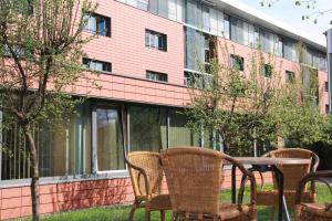 eine Terrasse mit Stühlen und einem Tisch vor einem Gebäude in der Unterkunft Jugendherberge Heidelberg International in Heidelberg