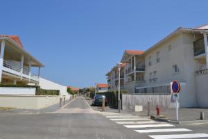 une rue vide avec des bâtiments et une bouche d'incendie rouge dans l'établissement Residence Oceanis, à Biscarrosse-Plage