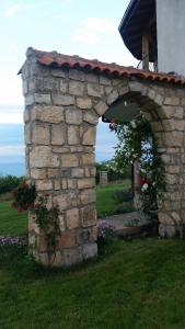 una pared de piedra con un arco en un patio en Morski Briz Houses, en Topola
