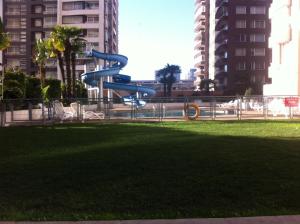 a blue slide in a park in a city at Departamento Viana in Viña del Mar