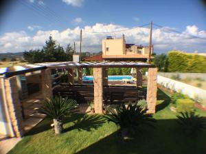 a backyard with a pergola and some plants at The Red Villa in Gennadi