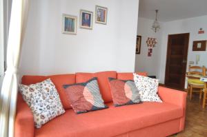 アルマカオ・デ・ペラにあるApartamento do Rioのリビングルーム(オレンジのソファ、枕付)