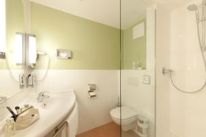 a bathroom with a toilet and a sink and a shower at ibis München City Süd in Munich +73 photos