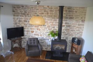a living room with a brick wall and a wood stove at Maison Del Traouc in Bozouls