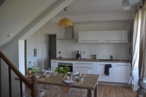 a kitchen with a wooden table and a dining room at Les Parenthèses Occitanes - Maison Del Traouc in Bozouls