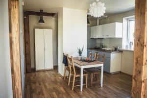 a kitchen and dining room with a table and chairs at Krauklis beach apartments in Saulkrasti