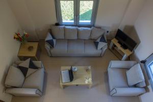 una vista aérea de una sala de estar con sofá y 2 sillas en Perivoli House B, en Skala Eresou
