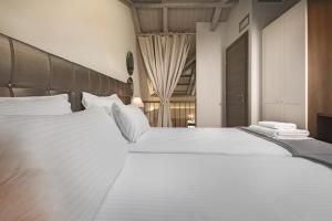 a bedroom with two large white beds with white pillows at Armonia Lux Studios in Ierissos