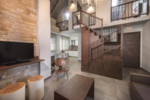 a living room with a staircase and a tv at Armonia Lux Studios in Ierissos