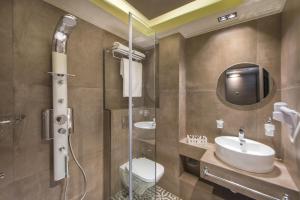 a bathroom with a sink and a toilet and a shower at Armonia Lux Studios in Ierissos +26 photos