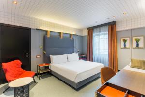 a hotel room with a bed and a desk and chairs at Room Mate Giulia in Milan