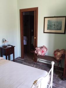 een slaapkamer met een bed, een tafel en een stoel bij Agriturismo Donna Beatrice in Bianco