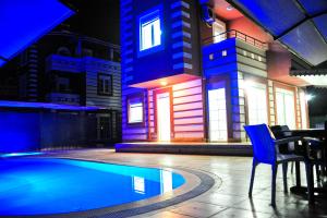 ベレキにあるHappyland SDT Villaの建物の隣に青い椅子付きのスイミングプール