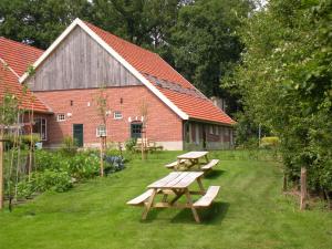 a group of picnic tables in front of a building at Erve Höwerboer in Ootmarsum