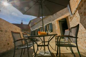 a table and chairs with an umbrella on a patio at Vacation home Vibor in Dračevica +9 photos