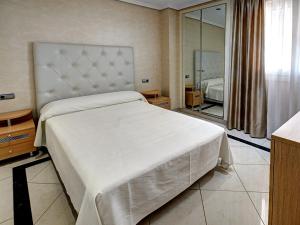 
a hotel room with a bed and a desk at Apartamentos Marina d'Or Beach 2ª Linea in Oropesa del Mar

