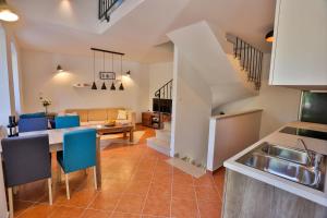 a kitchen and living room with a table and blue chairs at Vacation home Vibor in Dračevica