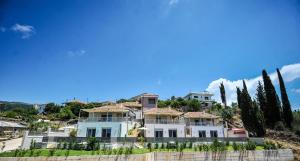 a large white house on a hill with trees at Casa Sivota in Syvota