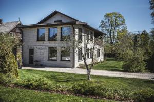 a house with a tree in the front yard at Krauklis beach apartments in Saulkrasti