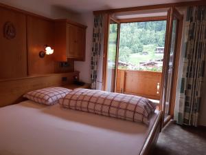 a bedroom with a bed and a large window at Pension Bergkristall in Tux