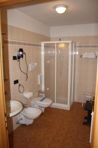 a bathroom with two toilets and a shower at HOTEL La Locanda in Pinzolo