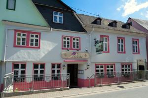 a white and red building with red windows at Hotel Blüchertal in Bacharach