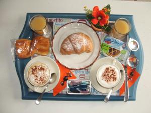 a tray of food with bread and two cups of coffee at B&B La Cubanina in Rome