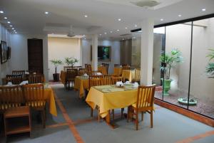 a restaurant with tables and chairs with yellow table cloth at Pousada Cambucá de Cabo Frio in Cabo Frio