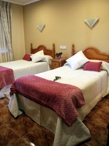 sypialnia z 2 łóżkami z czerwonymi i białymi kocami w obiekcie Hostal pachin w mieście Mieres