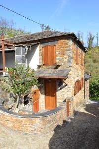 Cette maison en pierre est entourée d'un mur en pierre. dans l'établissement Casa da Arvore - Paradinha, à Paradinha