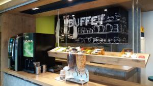 a coffee shop with a counter with a drink machine at ibis budget Concarneau in Concarneau