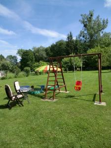 a playground with a swing and a chair in a field at Ferienwohnung Kehmeier in Polle