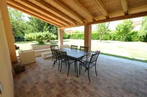 a patio with a table and chairs under a wooden ceiling at antiche distillerie "buon dormire" in Pincara