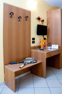 um quarto com uma secretária de madeira com um computador e ferramentas em Hotel Agata em Biella
