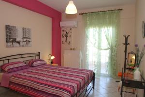 a bedroom with a bed and a large window at Tritsa House, 3-bedroom apt next to Corfu Town and airport in Corfu