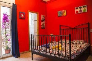 バルセロナにあるApartamento Rosellónの赤い壁のベッドルーム1室、ベビーベッド1台が備わります。