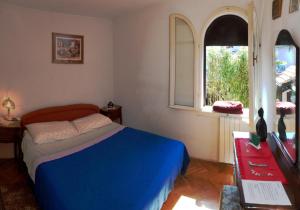 a bedroom with a blue bed and a window at Apartment Nevica in Split