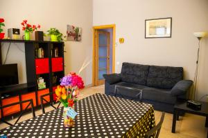 uma sala de estar com um sofá e uma mesa com flores em Apartamento Rosellón em Barcelona