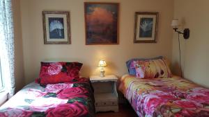 a bedroom with two beds and a table with a lamp at Woodside Inn in Harrison Mills