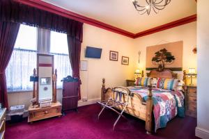 1 dormitorio con cama de madera y espejo en Creston Villa Guest House en Lincoln