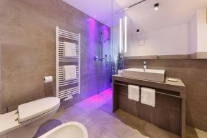 a bathroom with a toilet and a sink with purple lights at Gasthof Weber in Petersberg