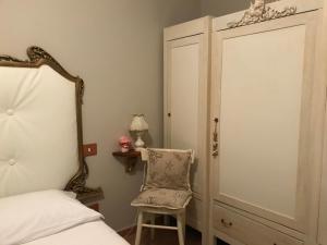 una camera con un letto e una sedia accanto a una porta di Ancora bilocale a Marina di Massa